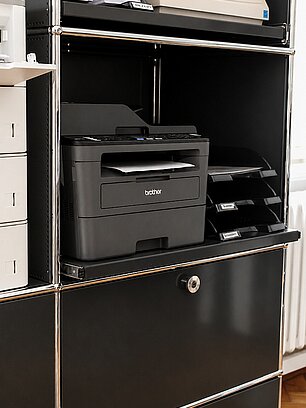 Office shelf with Brother laser printer and supplies organized neatly