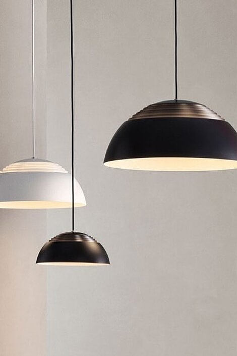 Drei moderne Pendelleuchten in Schwarz und Weiß vor einer neutralen Wand