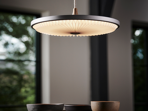 Moderne Pendelleuchte über gedecktem Tisch mit Keramikschalen bei natürlichem Licht