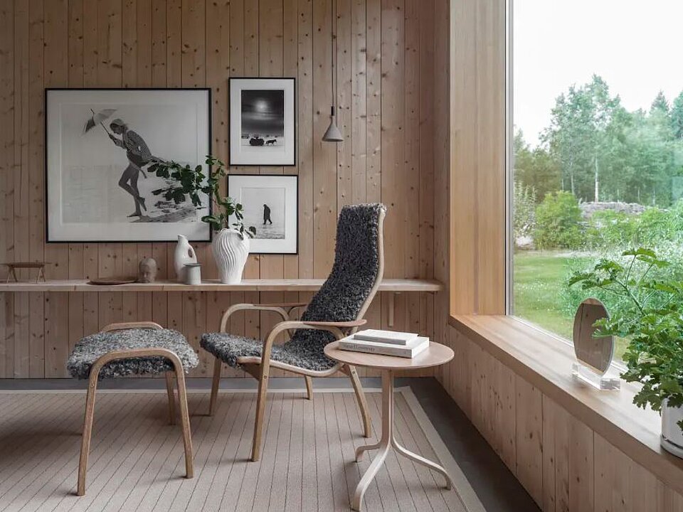 Skandinavischer Lesebereich mit Liegesessel, Holzverkleidung und Blick ins Grüne