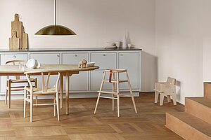 Minimalistische skandinavische Küche mit Holzstühlen, Esstisch und Hängelampe