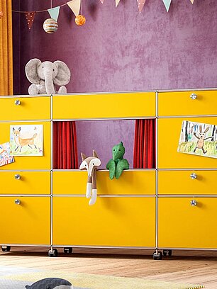 Gelber modularer Kinderzimmerschrank mit Spielpuppen, Zeichnungen und rotem Vorhang