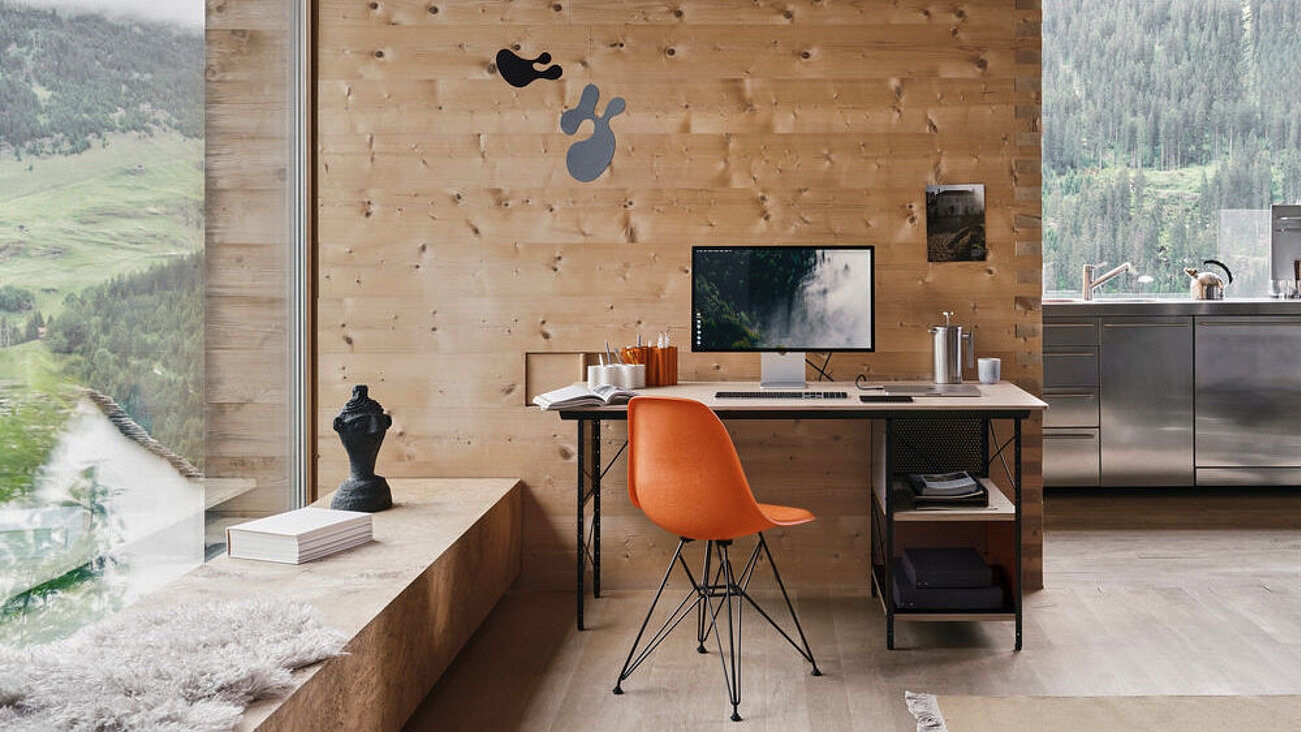 Modernes Heimbüro mit Holzverkleidung, großem Fenster und orangefarbenem Stuhl