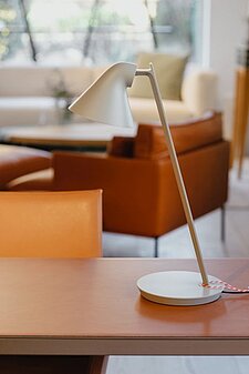 Moderne Schreibtischlampe auf einem Holztisch in stilvoll eingerichtetem Wohnzimmer