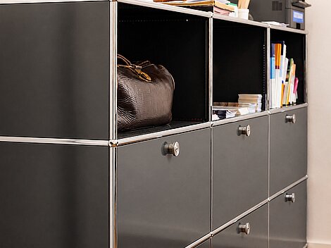 Modern office shelves with file folders and a leather bag