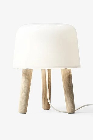 Moderne Tischlampe mit weißem Schirm und drei Holzbeinen im minimalistischen Design