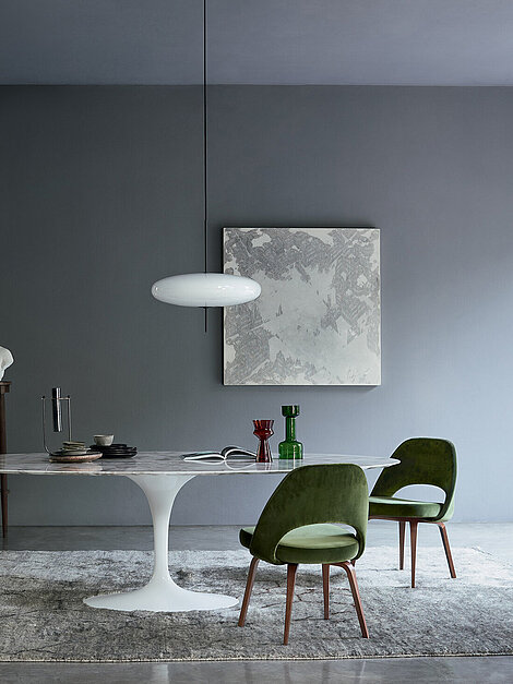 Modernes Esszimmer mit Marmortisch, Samtstühlen und Skulptur auf grauem Teppich