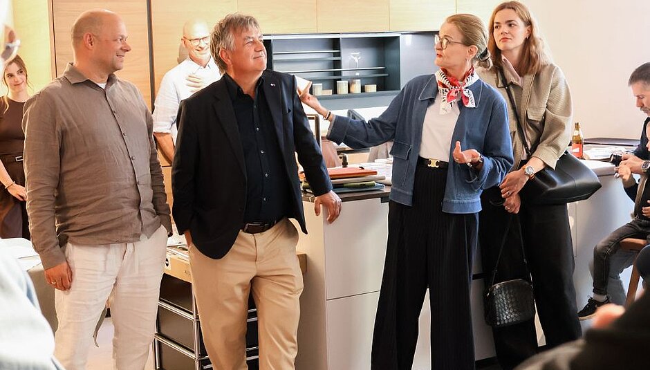 Group of people talking in a modern kitchen showroom