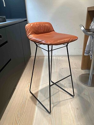 Moderner Barhocker mit brauner Lederpolsterung und schwarzem Metallgestell in einer Küche