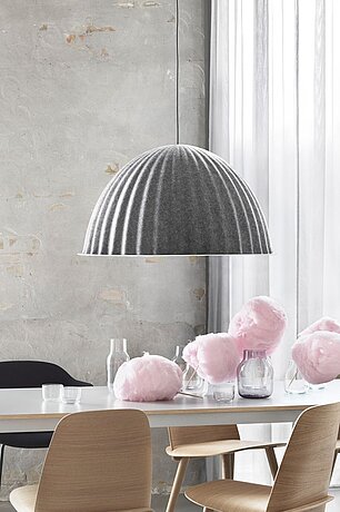 Moderner Essbereich mit grauer Filzlampe, Holzstühlen und rosa Zuckerwatte auf dem Tisch