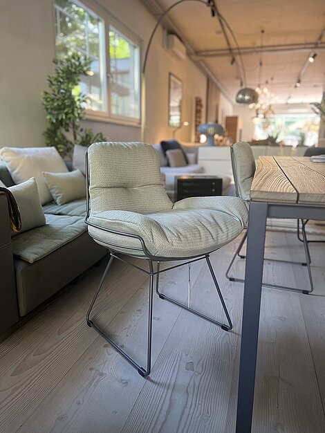 Moderner gepolsterter Stuhl mit Metallgestell in stilvollem Wohnzimmer mit Holzboden
