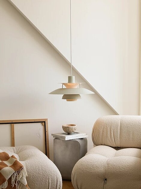 Modernes Wohnzimmer mit beigen Sofas, Pendelleuchte und minimalistischer Inneneinrichtung