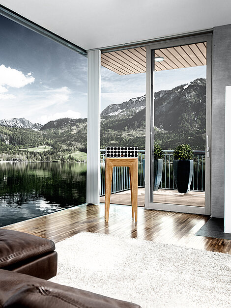 Modernes Wohnzimmer mit Kamin und Panoramafenstern mit Blick auf See und Alpenlandschaft
