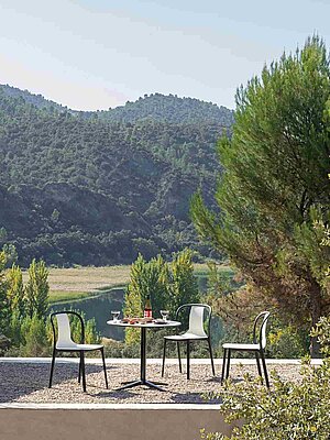 Scenic patio with chairs and table overlooking a green forested landscape