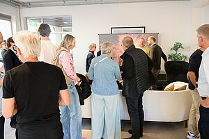 Group of people socializing in a modern living room with bright lighting